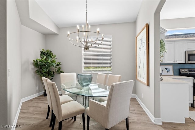 dining room with light wood-type flooring and a chandelier