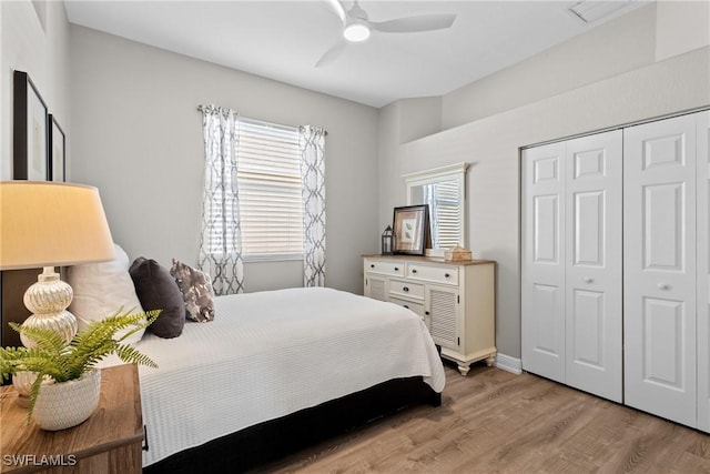 bedroom featuring multiple windows, a closet, ceiling fan, and light hardwood / wood-style floors