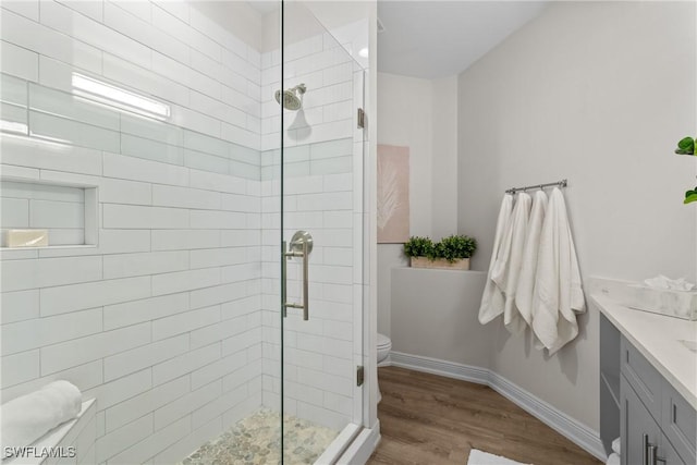 bathroom with wood-type flooring, vanity, toilet, and walk in shower