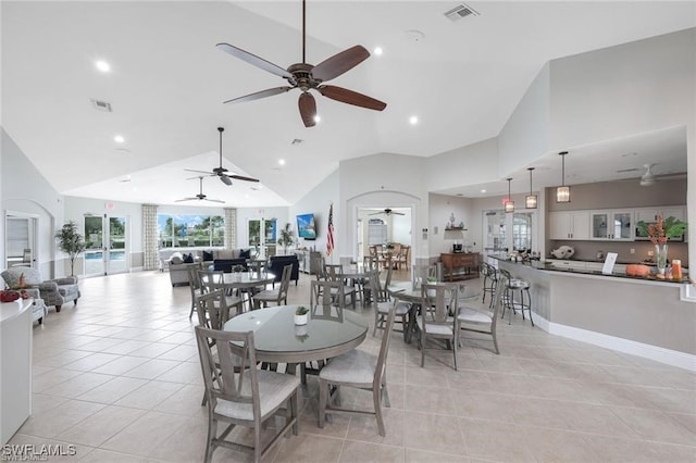 dining space with lofted ceiling, ceiling fan, and light tile patterned floors