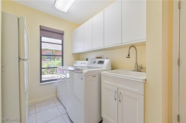 clothes washing area with cabinets, separate washer and dryer, sink, and light tile patterned floors