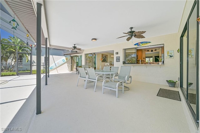 view of patio featuring glass enclosure and ceiling fan