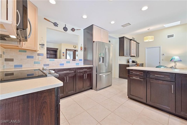 kitchen featuring decorative light fixtures, decorative backsplash, dark brown cabinets, light tile patterned floors, and appliances with stainless steel finishes