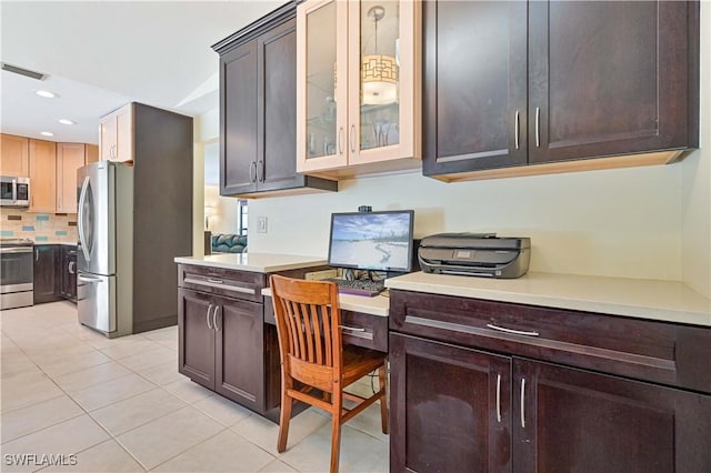 kitchen featuring backsplash, dark brown cabinets, light tile patterned floors, and appliances with stainless steel finishes