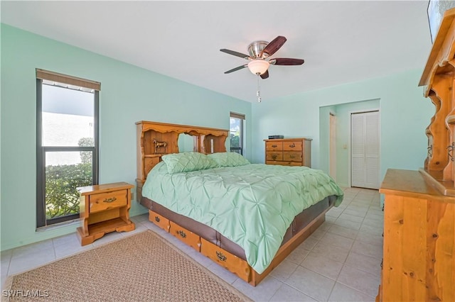 tiled bedroom featuring ceiling fan and a closet