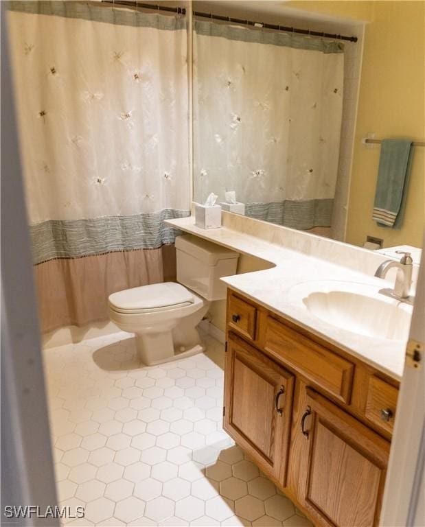 bathroom with tile patterned floors, vanity, a shower with shower curtain, and toilet