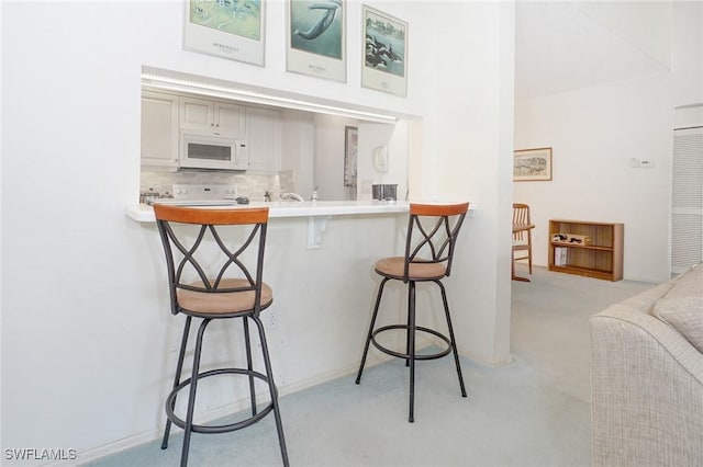 interior space featuring a breakfast bar, kitchen peninsula, and tasteful backsplash