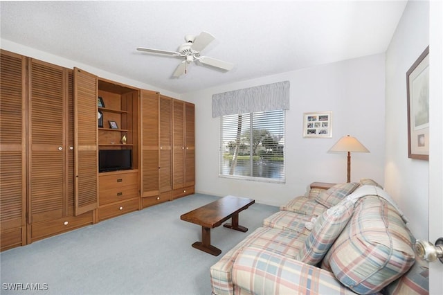 carpeted living room with ceiling fan