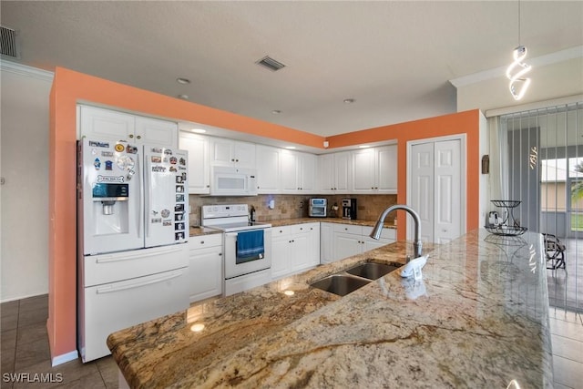 kitchen featuring light stone countertops, white appliances, sink, white cabinetry, and hanging light fixtures