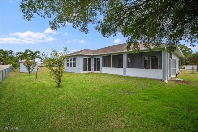 rear view of property with a sunroom and a yard