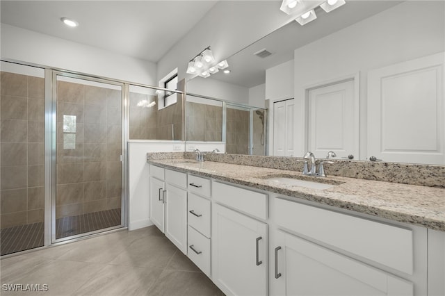 bathroom featuring tile patterned flooring, vanity, and walk in shower