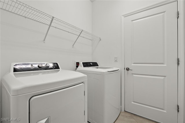 clothes washing area featuring separate washer and dryer and light tile patterned flooring