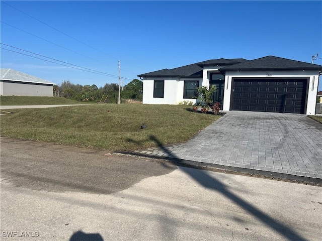 view of front of home featuring a garage and a front yard