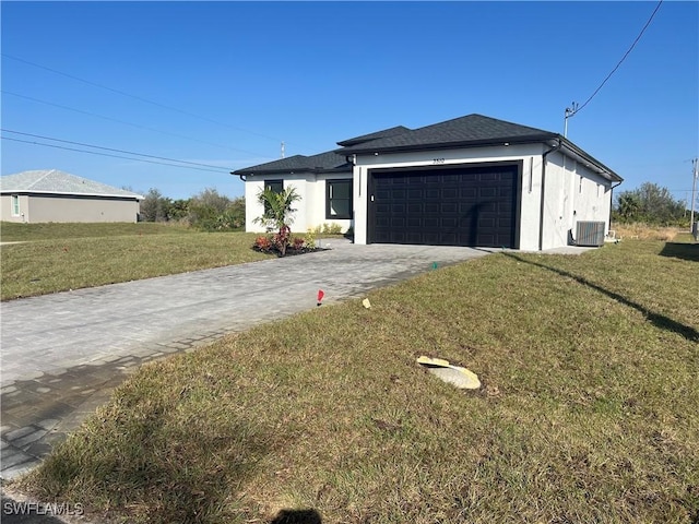 view of front of property featuring a garage, a front yard, and central AC