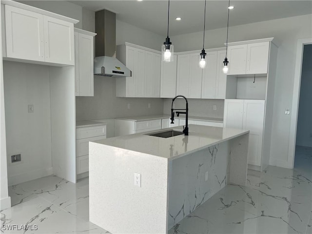 kitchen featuring a center island with sink, white cabinetry, wall chimney exhaust hood, and sink