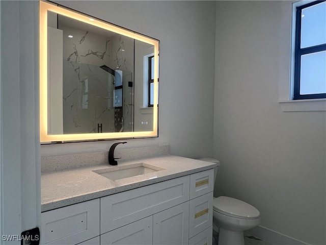 bathroom with a shower, vanity, and toilet