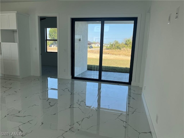 spare room with marble finish floor and baseboards