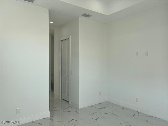 empty room with marble finish floor, recessed lighting, visible vents, and baseboards