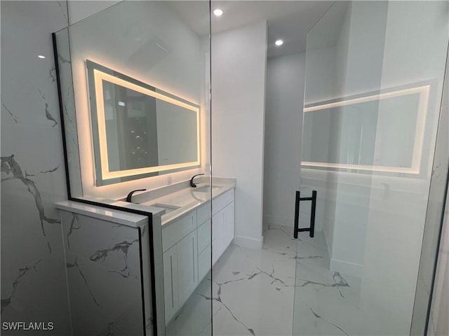 full bath featuring marble finish floor, double vanity, a sink, and a marble finish shower