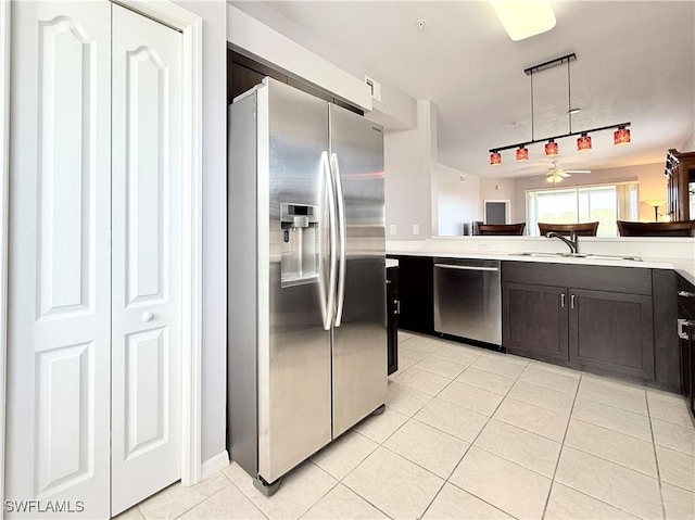 kitchen with appliances with stainless steel finishes, dark brown cabinetry, light tile patterned floors, and ceiling fan