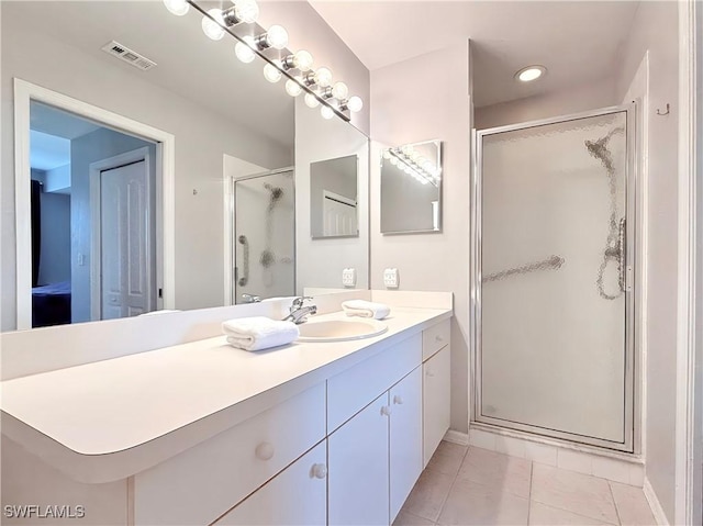 bathroom with tile patterned floors, vanity, and a shower with door