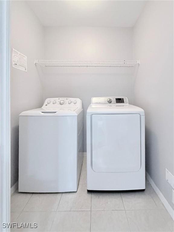 washroom featuring light tile patterned floors and washer and clothes dryer