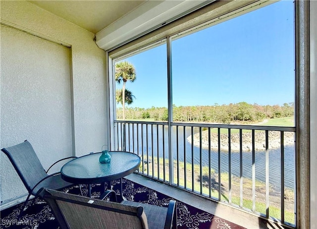 sunroom featuring a water view