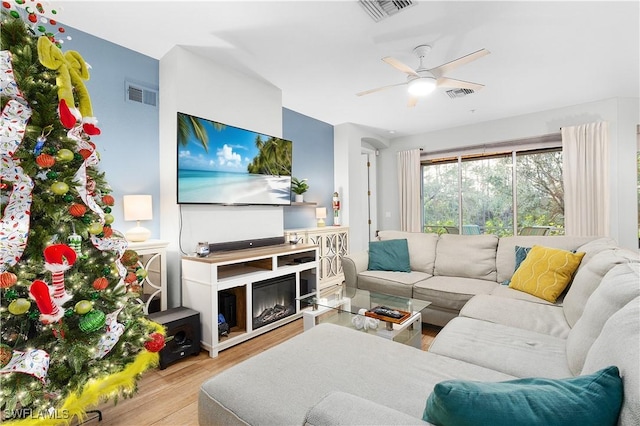 living room with light hardwood / wood-style flooring and ceiling fan