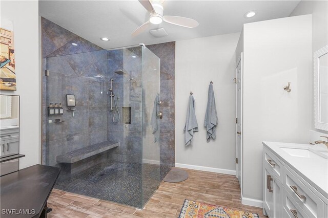 full bath with a ceiling fan, wood tiled floor, vanity, a walk in shower, and baseboards