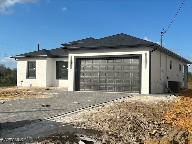 view of front of home featuring cooling unit and a garage