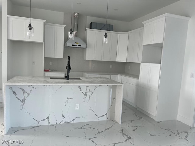 kitchen with white cabinets, pendant lighting, and a kitchen island with sink