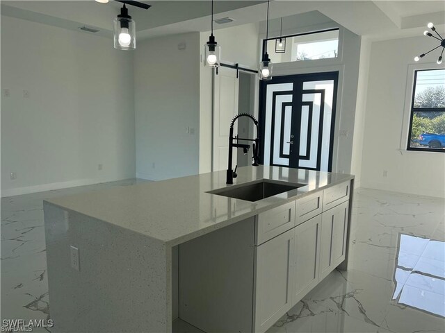 kitchen featuring marble finish floor, white cabinets, and hanging light fixtures