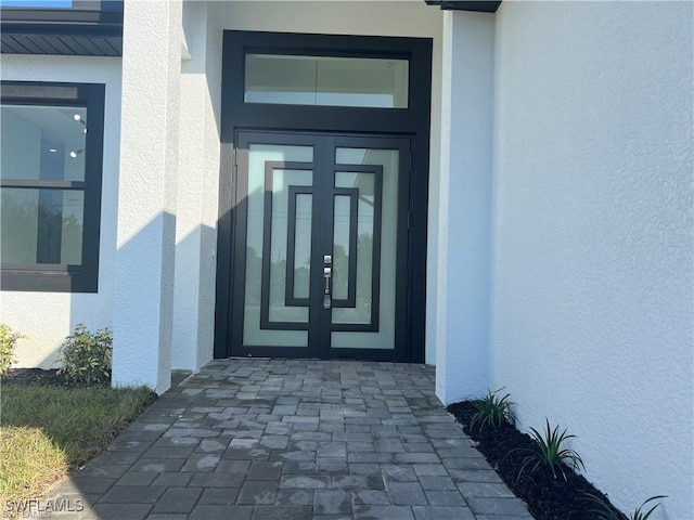 property entrance featuring french doors and stucco siding