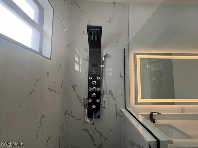 interior space with a marble finish shower and vanity