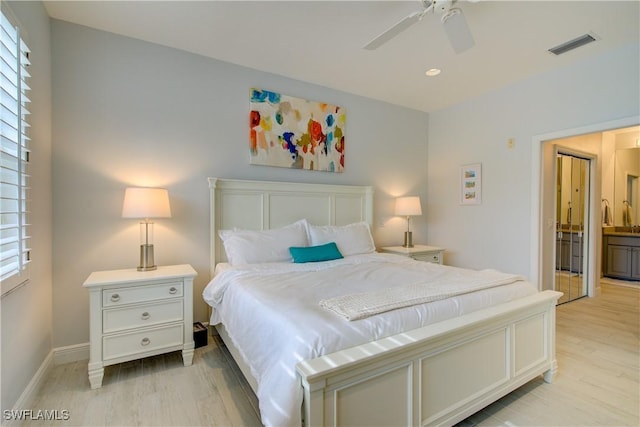 bedroom featuring light wood-type flooring, visible vents, connected bathroom, and baseboards