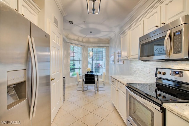 kitchen with ornamental molding, light stone counters, light tile patterned floors, and appliances with stainless steel finishes