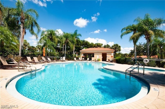 community pool featuring a patio area and fence