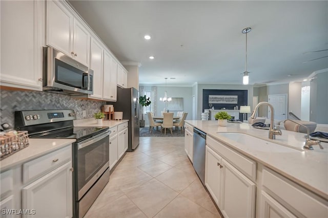 kitchen with sink, white cabinets, decorative light fixtures, and appliances with stainless steel finishes