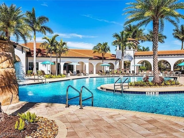 view of pool featuring pool water feature and a patio