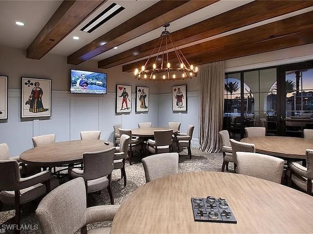 carpeted dining space with beam ceiling and a chandelier