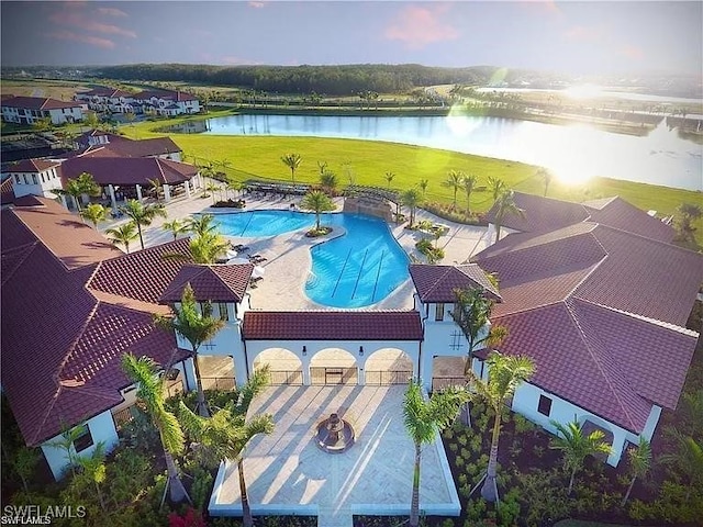 pool at dusk featuring a water view