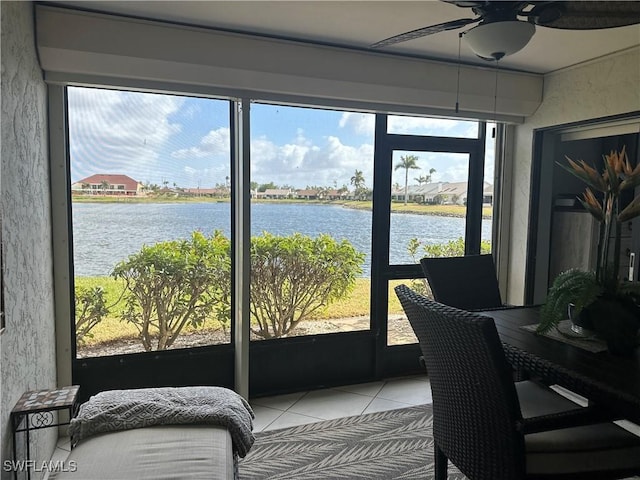 sunroom / solarium with ceiling fan, a water view, and a healthy amount of sunlight