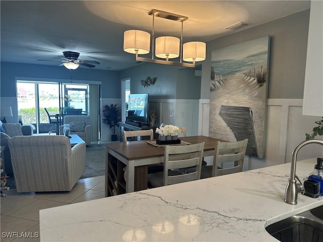 kitchen featuring ceiling fan, sink, light tile patterned floors, and decorative light fixtures