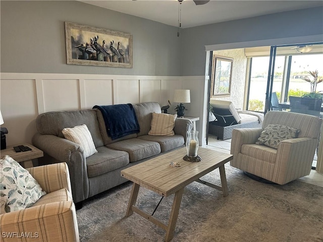 living room with ceiling fan and dark colored carpet