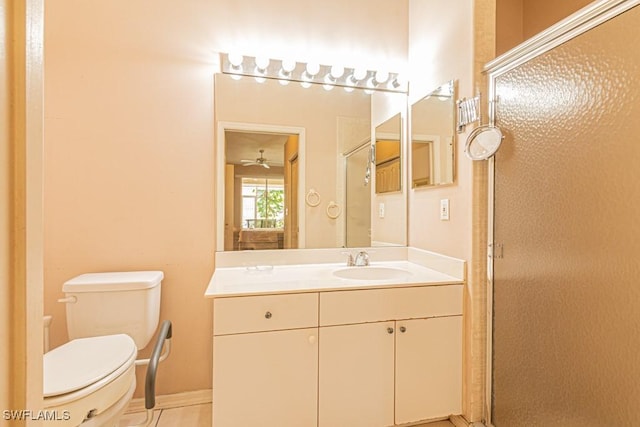 bathroom featuring ceiling fan, toilet, vanity, and walk in shower