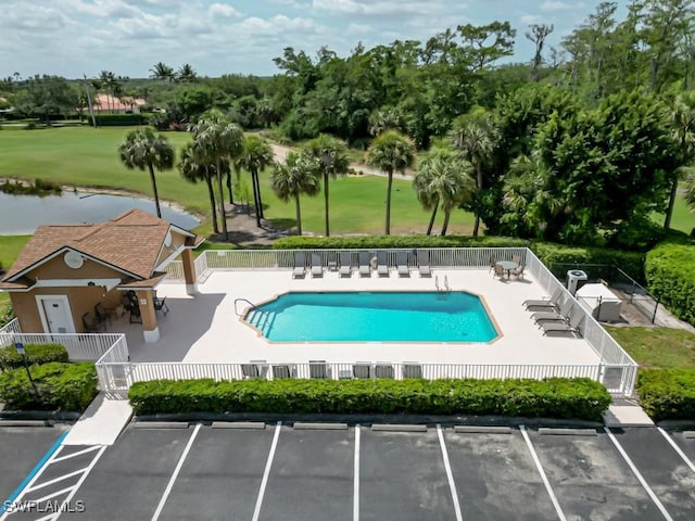 view of pool with a water view and a patio