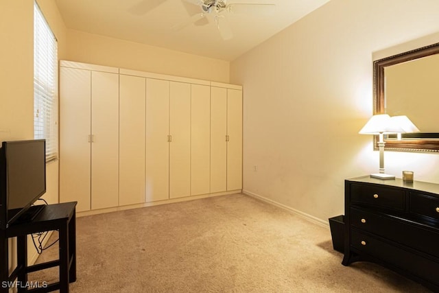 bedroom featuring ceiling fan, light colored carpet, and a closet