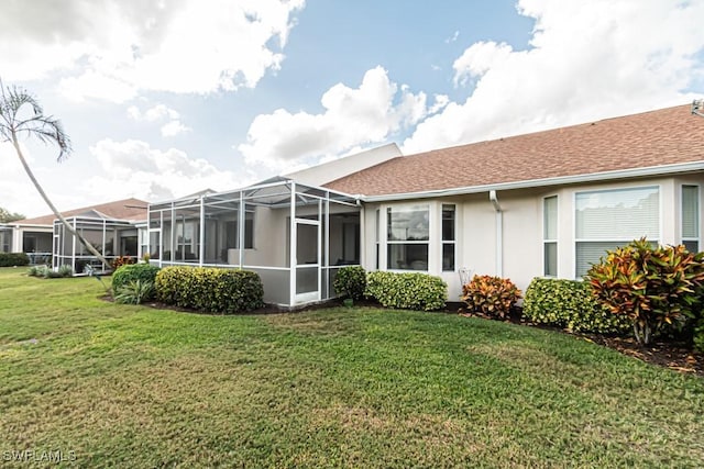 rear view of property with a lanai and a lawn