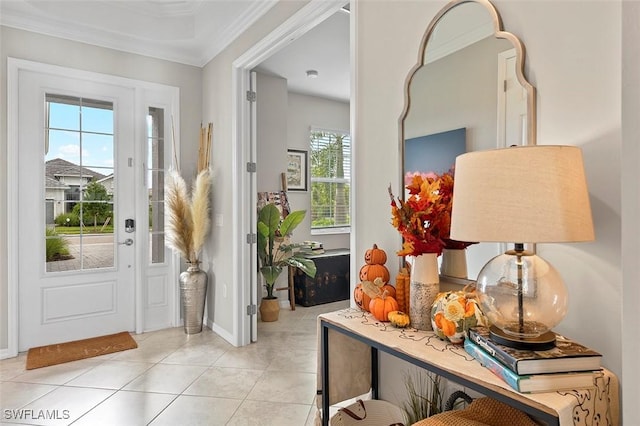 entrance foyer with plenty of natural light, light tile patterned floors, and ornamental molding