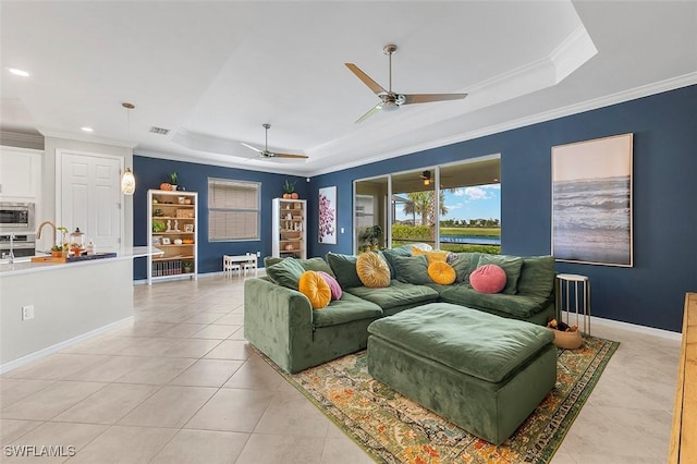 tiled living room featuring ceiling fan, crown molding, and a tray ceiling